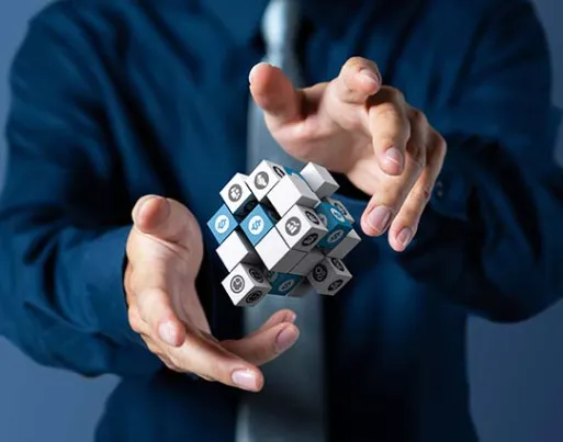 a cubic box with multiple IT icons on it and a person hovering his hands over it